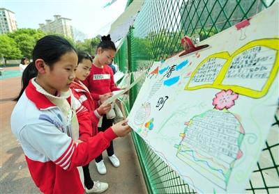 师生们在参观自己动手制作的清明节手抄报