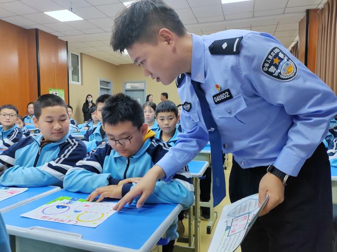 高碑店市东盛派出所民警卜帅正在与学生们观看 反网络诈骗 主题手抄报